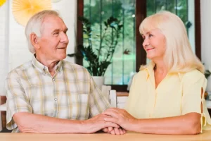 A peaceful senior couple sitting together on a table. smiling and enjoying a quiet moment of connection.